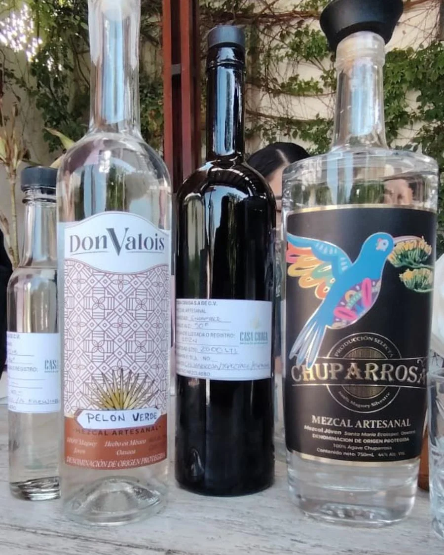Botellas de Don Valois y Chuparrosa en una mesa al aire libre